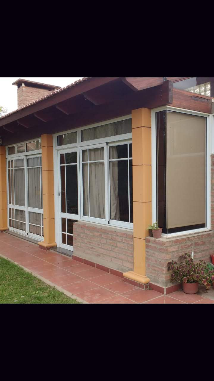 Galería con puertas y ventanas blancas junto a columnas y muros de ladrillo