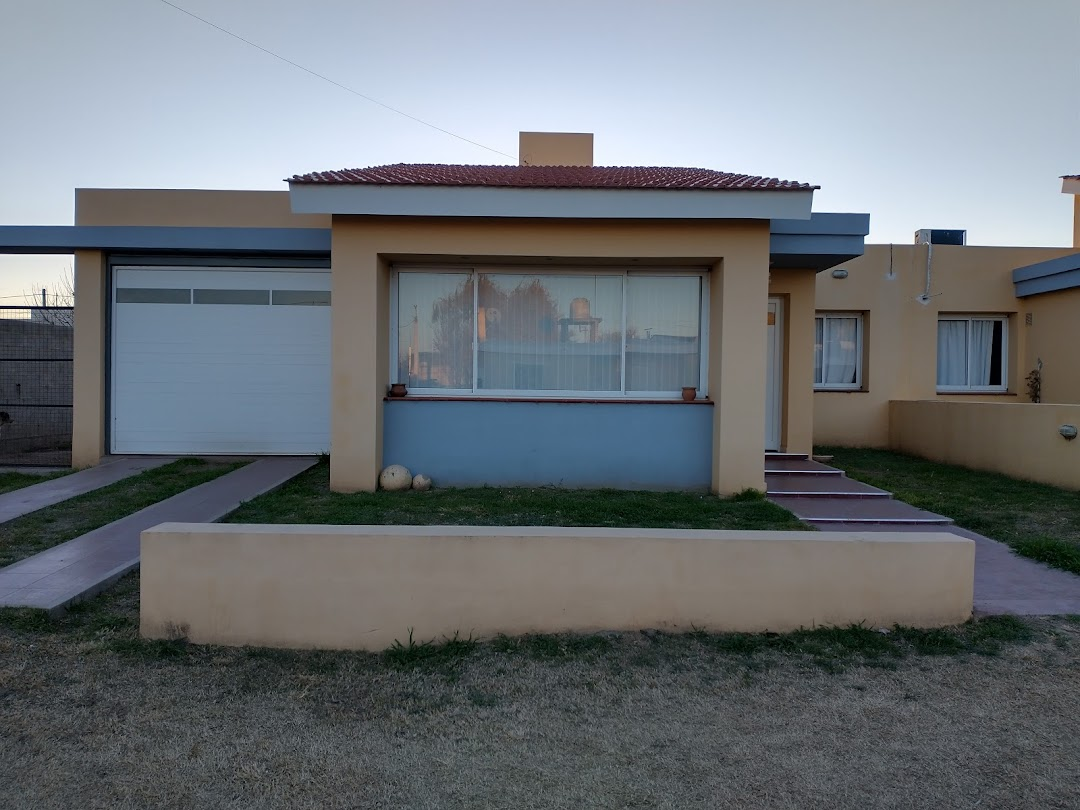 Fachada de vivienda con ventana amplia, ventanas laterales y portón blanco