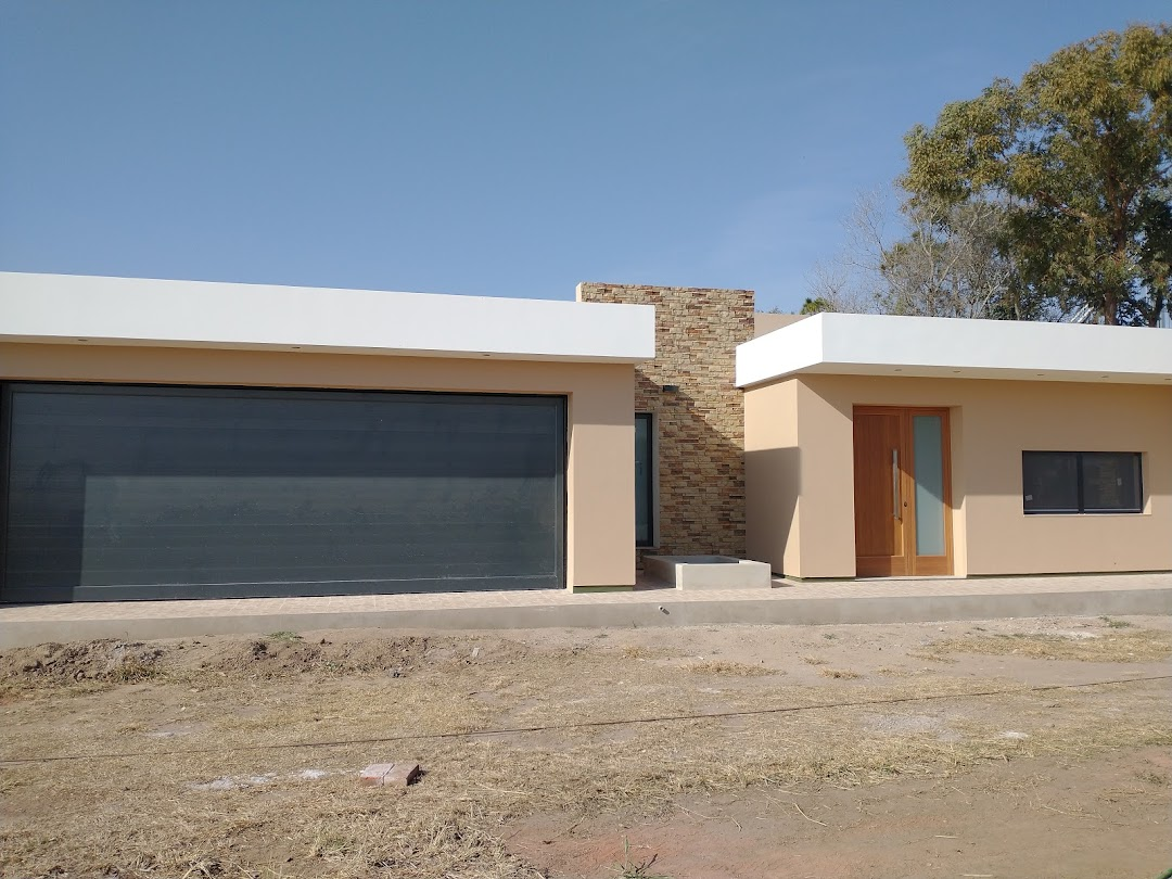 Vivienda de líneas rectas con portón oscuro, puerta en tono madera y ventana horizontal