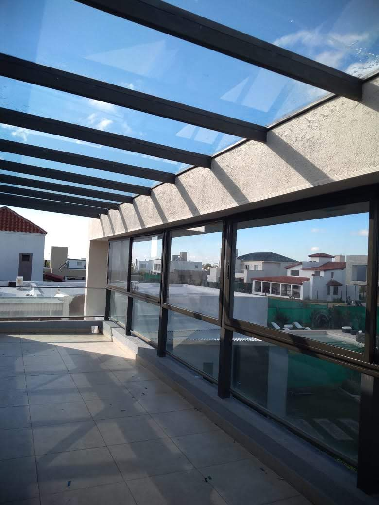 cerramiento de terraza con techo vidriados y ventanas corredizas adosado a paños fijos