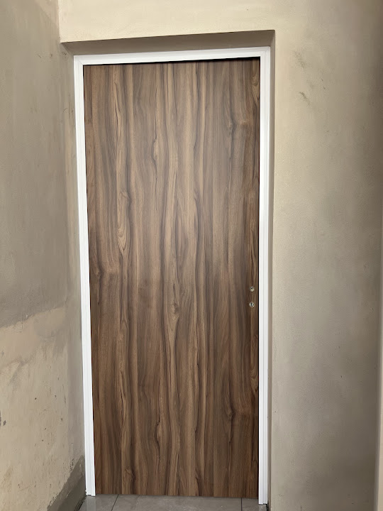 Puerta de terminación símil madera con marco blanco en aluminio