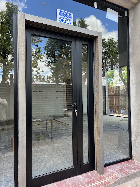 Puerta vidriada oscura con paño fijo lateral