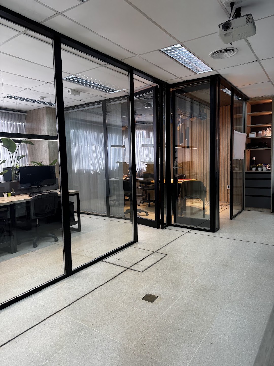 Trabajo de Actis: cerramiento de oficina con perfiles negros y puertas de vidrio
